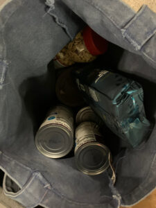 canned food, a bag of coffee, and a jar of peanuts in a cloth bag